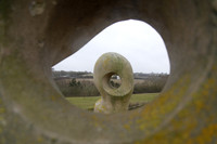 One statues seen through the 'eye' of another in Folly Park Faringdon
